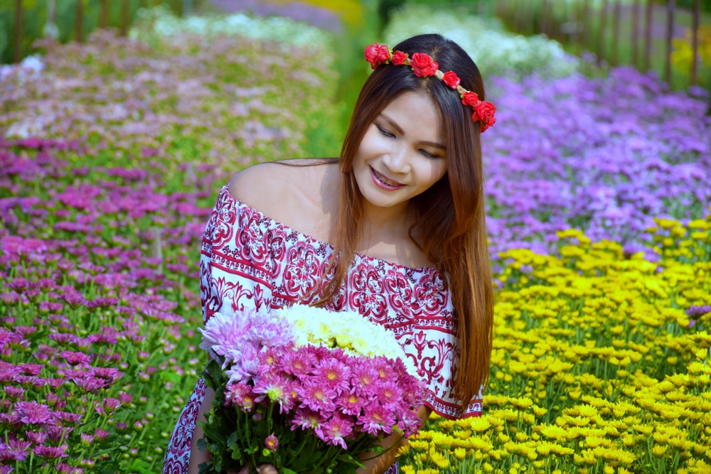 ผู้หญิงถือช่อดอกไม้ในทุ่งที่สระบุรีธรรมชาติ