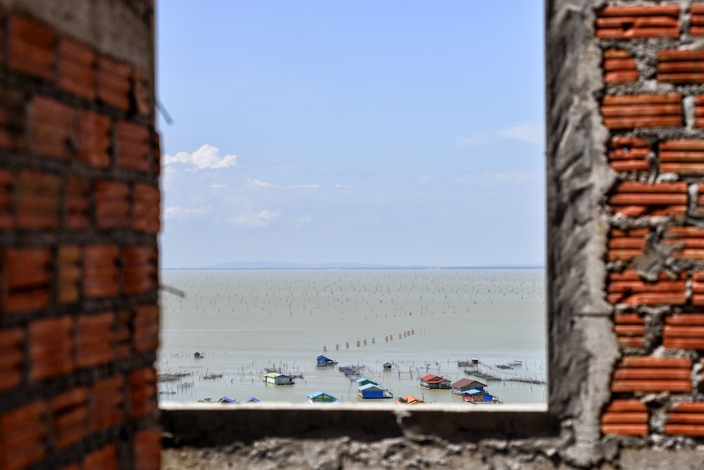 ผนังอิฐมองเห็นวิวทะเลผ่านหน้าต่างในราชบุรีที่เที่ยว ที่เที่ยวหาดใหญ่