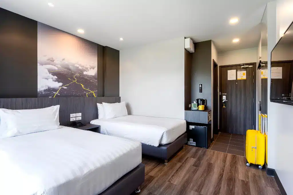 ห้องพักโรงแรมในเชียงใหม่พร้อมเตียง 2 เตียงและกระเป๋าเดินทาง ที่พักเชียงใหม่