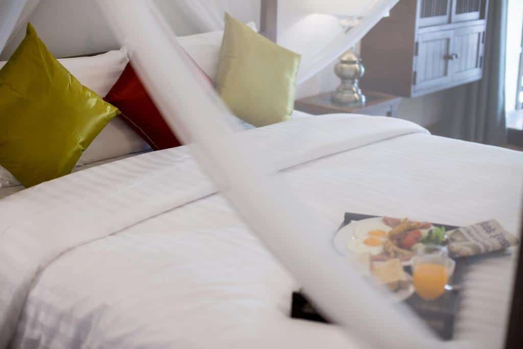 เตียงในห้องที่มีถาดอาหารอยู่บนนั้นเป็นจุดท่องเที่ยวราชบุรี ( โรงแรมเชียงใหม่