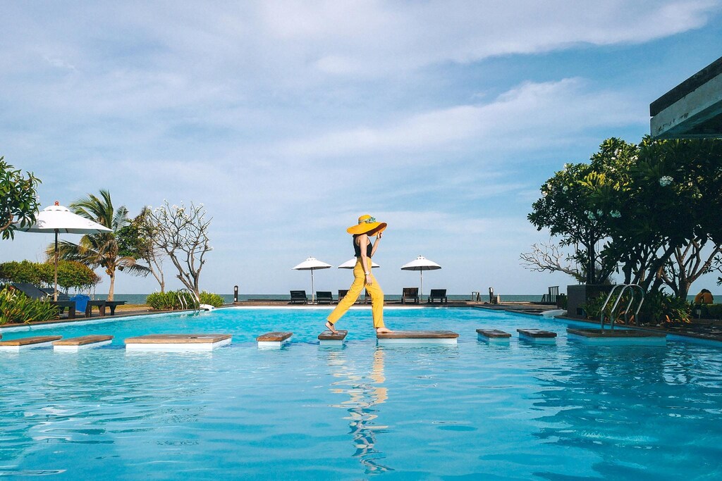 ผู้หญิงสวมหมวกสีเหลืองยืนอยู่ในสระว่ายน้ำ ที่พักหาดเจ้าสำราญเพชรบุรี