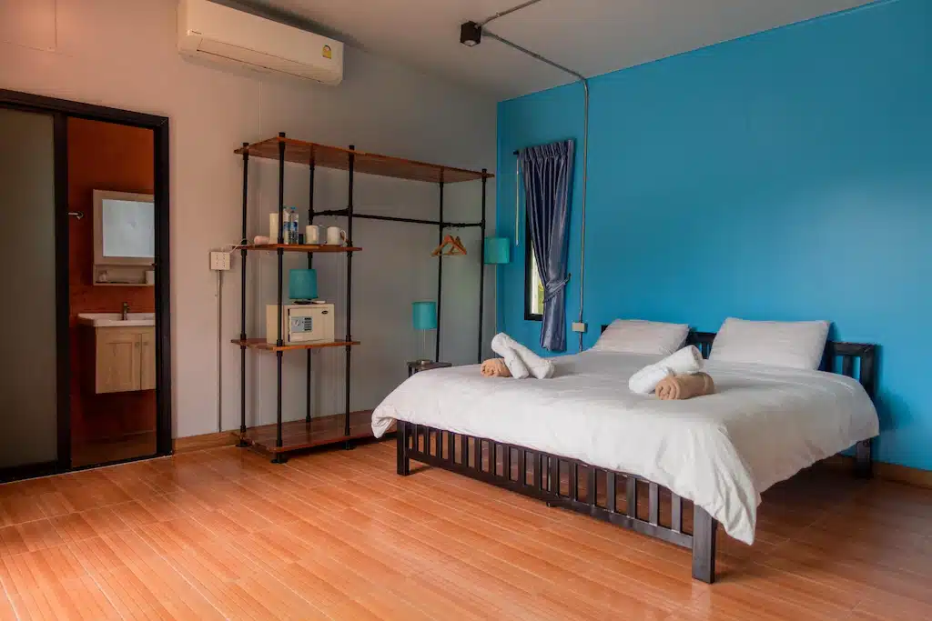 ห้องนอนผนังสีฟ้าและ เกาะกูดที่พัก พื้นไม้ ตั้งอยู่ในเที่ยวราชบุรี