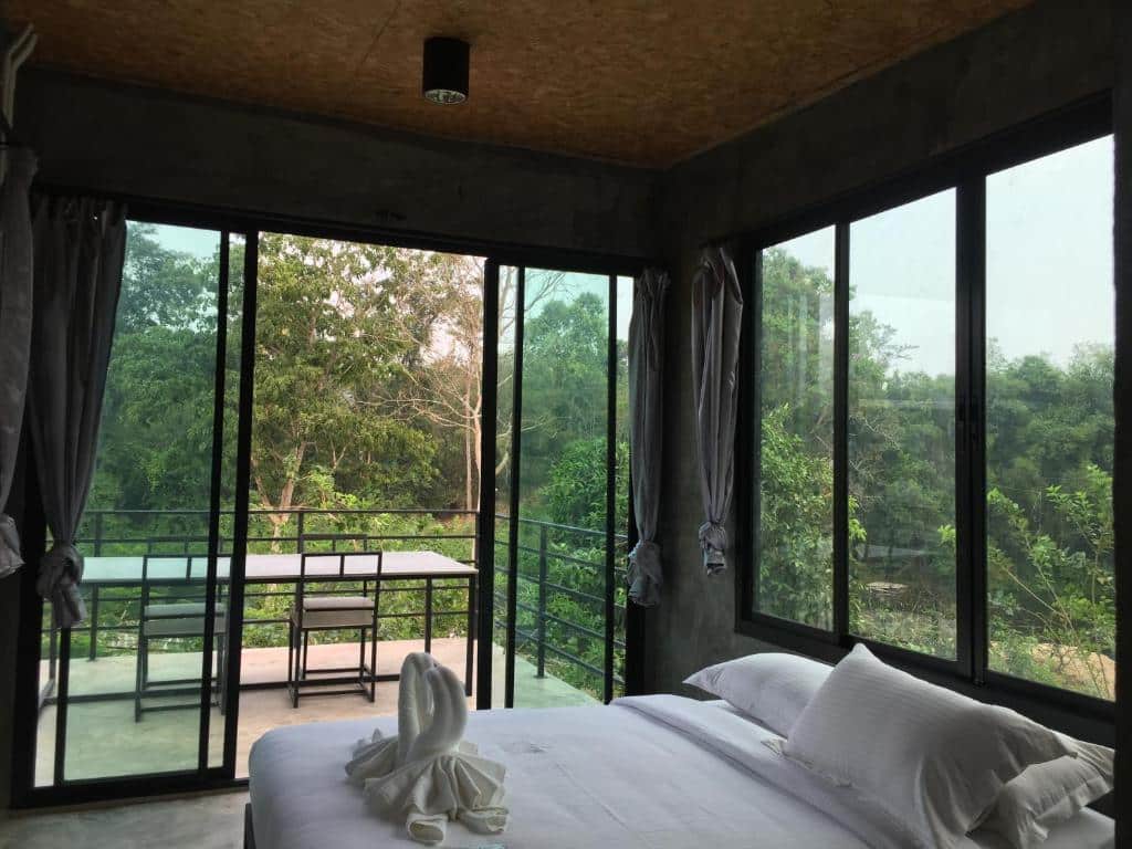 เตียงในห้องที่มีระเบียงมองเห็นวิวป่า เหมาะสำหรับผู้รักธรรมชาติที่แสวงหาความเงียบสงบ แก่งกระจานที่พัก