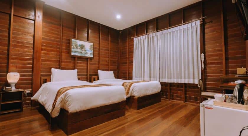 เตียงหรือเตียงในห้องที่มีผนังไม้ ที่พักอัมพวา
