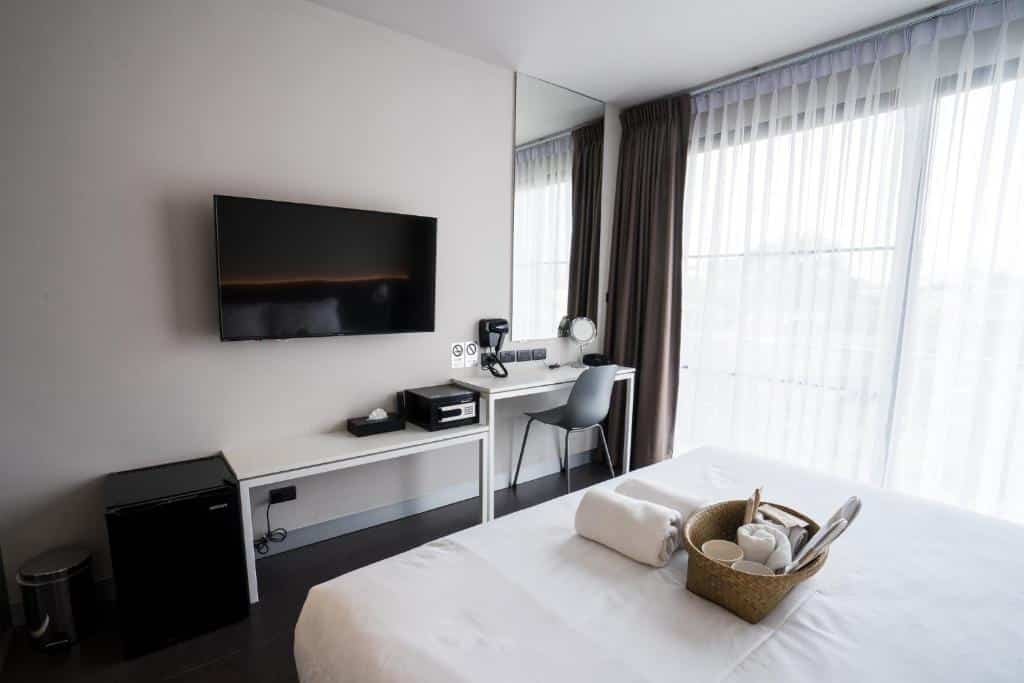 ห้องพักในโรงแรมพร้อมเตียง โต๊ะ และทีวีในเที่ยวราชบุรี ที่พักเชียงใหม่