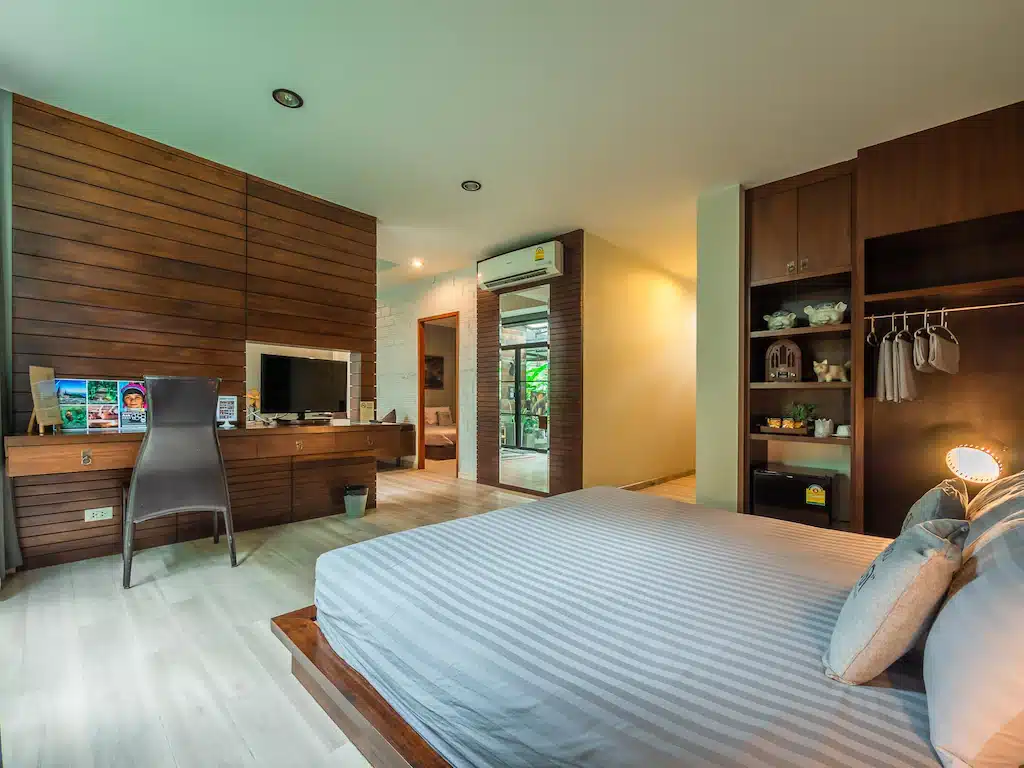 ห้องนอนผนังไม้และเตียงในราชบุรี รีสอร์ทเชียงใหม่
