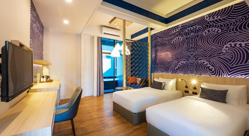 ห้องพักในโรงแรมที่มีสองเตียงและโทรทัศน์ ที่พักหาดเจ้าหลาว