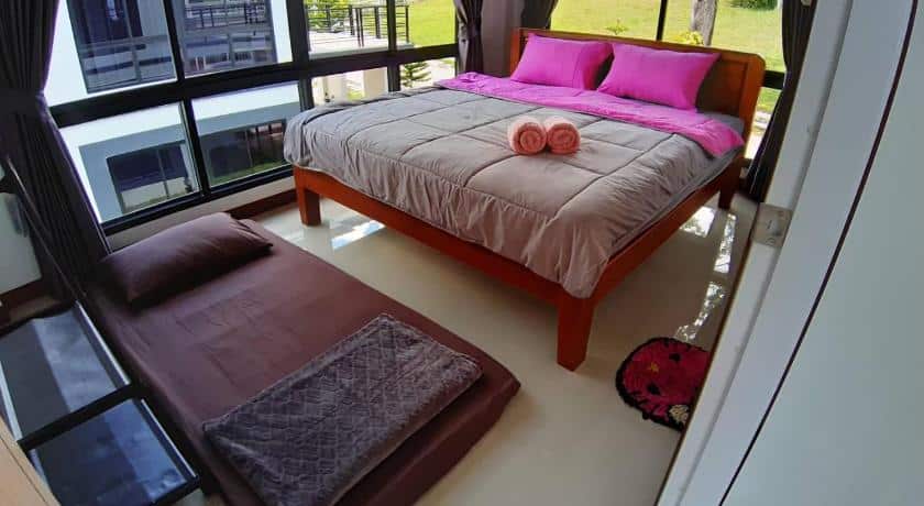 เตียงในห้องที่มีผ้านวมสีชมพู รีสอร์ทเขาค้อ