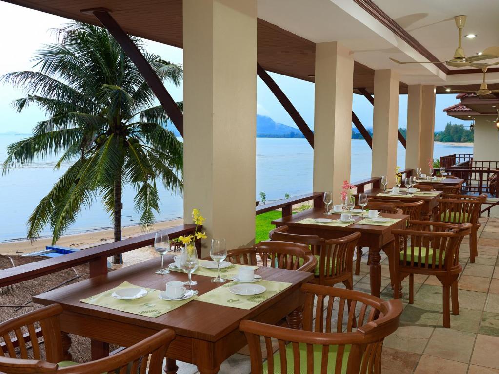 ร้านอาหารริมชายหาดพร้อมโต๊ะและเก้าอี้ที่มองเห็นวิวทะเล ที่พักชุมพรติดทะเล
