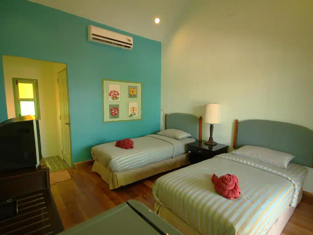 เตียง 2 เตียงในห้องเปิดใหม่ผนังสีฟ้า ให้บริการที่พักราคาประหยัดในอัมพวาและเป็นทางเลือกโฮมสเตย์ ที่พักอัมพวาเปิดใหม่
