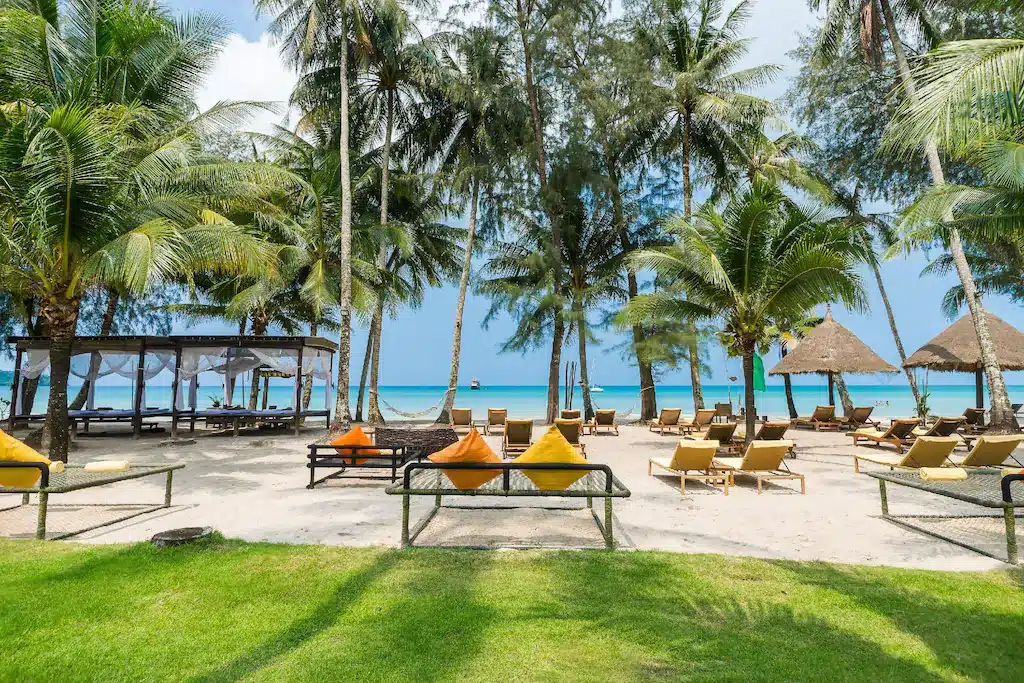 ชายหาดที่มีเก้าอี้นั่งเล่นและต้นปาล์มในราชบุรีที่เที่ยว ที่พักเกาะกูด