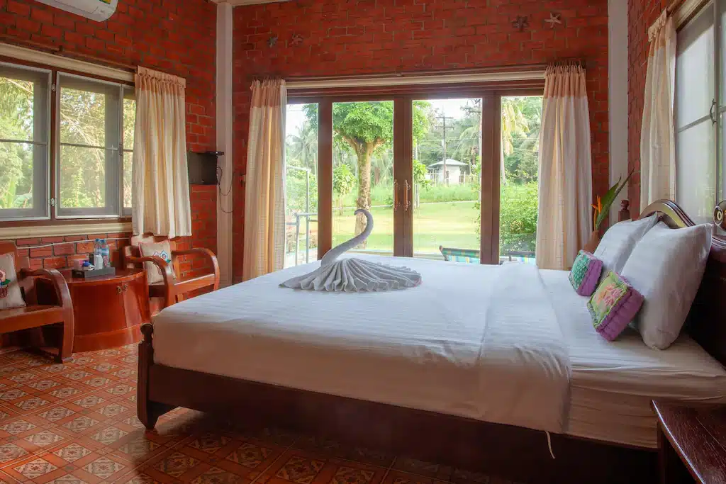 เตียงในห้องผนังอิฐแดง เหมาะสำหรับผู้ที่มาพักที่เที่ยวราชบุรีหรือกำลังมองหาที่พักเก เกาะกูดรีสอร์ท