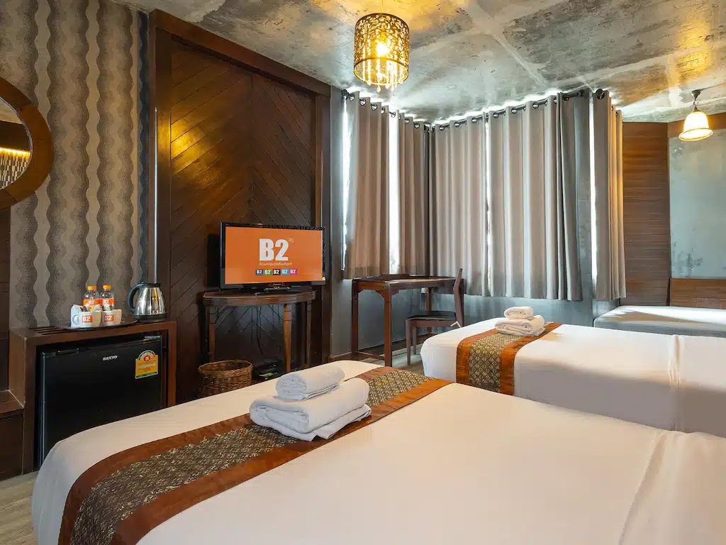 ห้องพักในโรงแรมที่มีสองเตียงและโทรทัศน์ เหมาะสำหรับการพักผ่อนใน รีสอร์ทเชียงใหม่ เชียงใหม่
