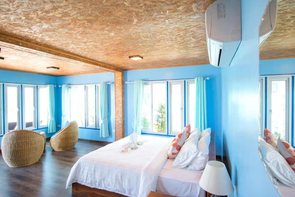 ห้องนอนผนังสีฟ้าและพื้นไม้ ตั้งอยู่ในราชบุรีที่เที่ยว ที่พักเกาะกูด