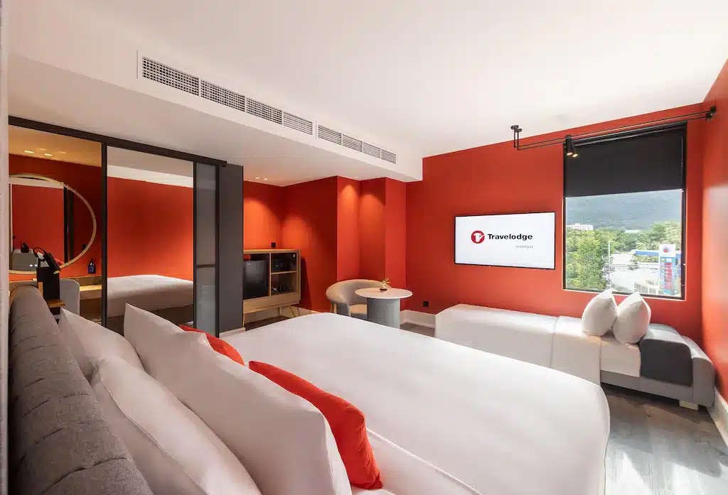 ห้องพักในโรงแรมที่ ที่พักเชียงใหม่ มีผนังสีแดงและโทรทัศน์