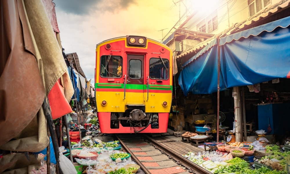 รถไฟสีแดงสีเหลืองที่เดินทางผ่านตลาดร่มหุบ ตลาดร่มหุบ