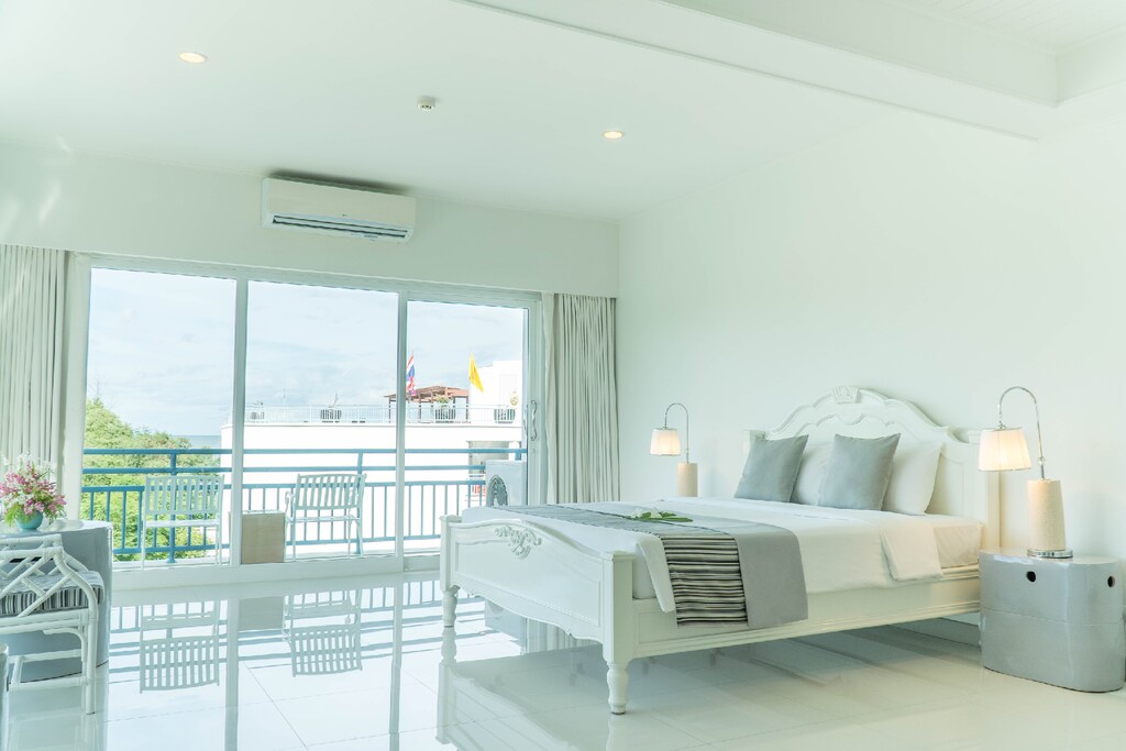 ห้องนอนสีขาวพร้อมระเบียงสวยมองเห็นวิวทะเลใกล้เขาค้อประเทศไทย ที่พักชะอําราคาถูก500ติดทะเล