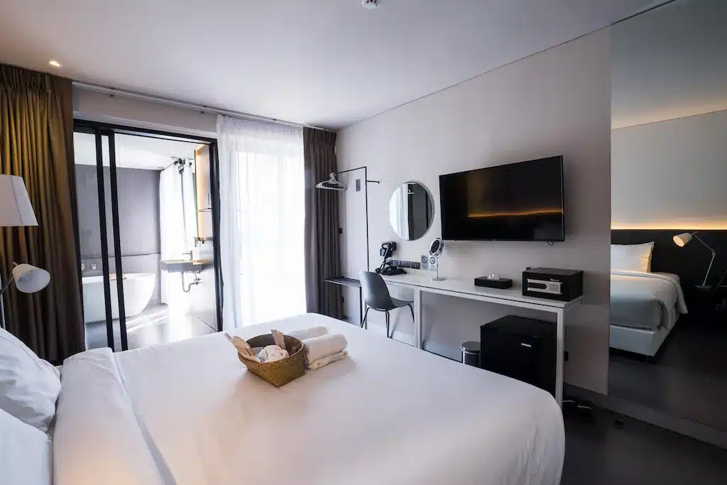 ห้องพักในโรงแรมพร้อมเตียง โต๊ะ และทีวีในเที่ยวราชบุรี ที่พักเชียงใหม่