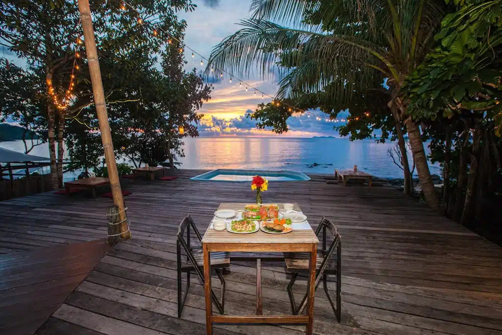 โต๊ะอาหารบนดาดฟ้ามีสระน้ำเป็นฉากหลัง ตั้งอยู่ในสถานที่ท่องเที่ยวจังหวัดราชบุรี ที่พักเกาะกูด