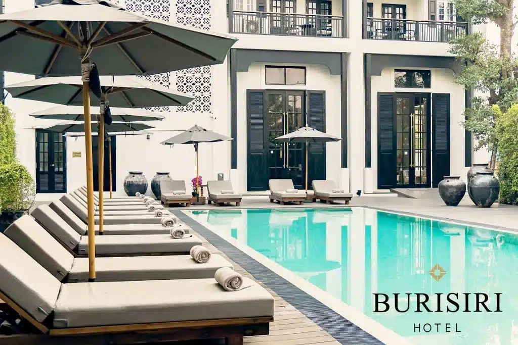 สระว่ายน้ำพร้อมเก้าอี้นั่งเล่นและร่มหน้าโรงแรมในพื้นที่ท่องเที่ยวราชบุรี โรงแรมเชียงใหม่