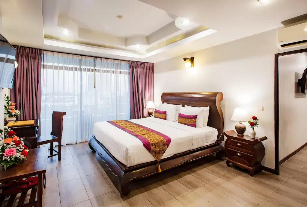 ห้องพักในโรงแรมที่มีเตียงขนาดใ ที่พักเชียงใหม่ หญ่และทีวีจอแบนในจุดท่องเที่ยวราชบุรี