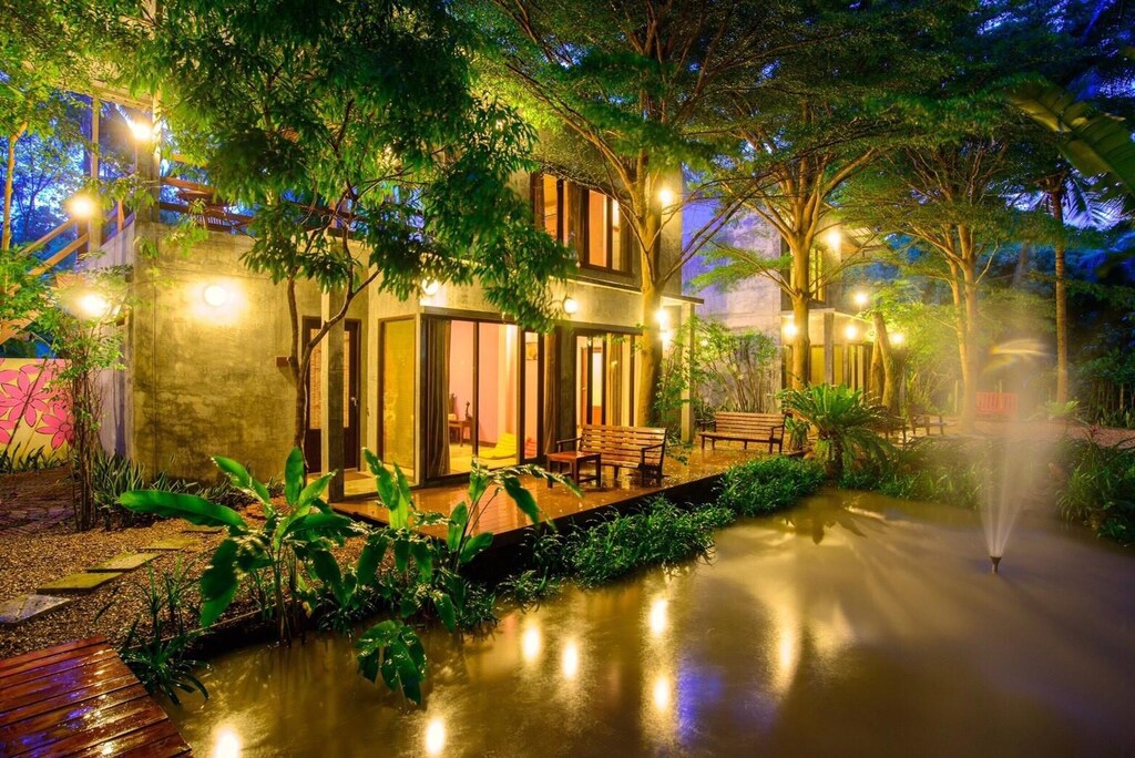บ้านที่มีสระน้ำและน้ำพุในเวลากลางคืน ที่พักอัมพวา