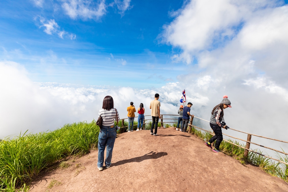 กลุ่มคนยืนอยู่บนยอดเขาในเพชรบูรณ์ที่เที่ยว มีเมฆเป็นฉากหลัง ที่เที่ยวเพชรบูรณ์