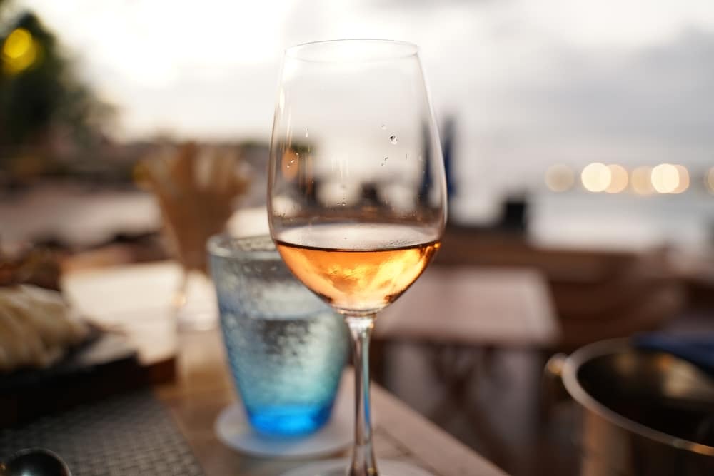 แก้วไวน์บนโต๊ะที่ร้านอาหารกลางแจ้งในเที่ยวพัทยาติดทะเล