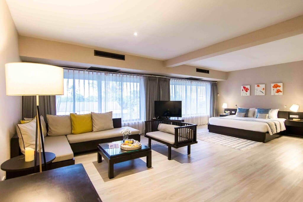 ห้องพักในโรงแรมที่มีเตียง โซฟา และโทรทัศน์ ที่พักอุบล