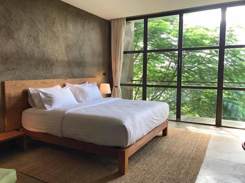 เตียงในห้องที่มีวิวต้นไม้ ที่พักใกล้สะพานมอญสังขละบุรีราคาถูก ที่สังขละบุรี