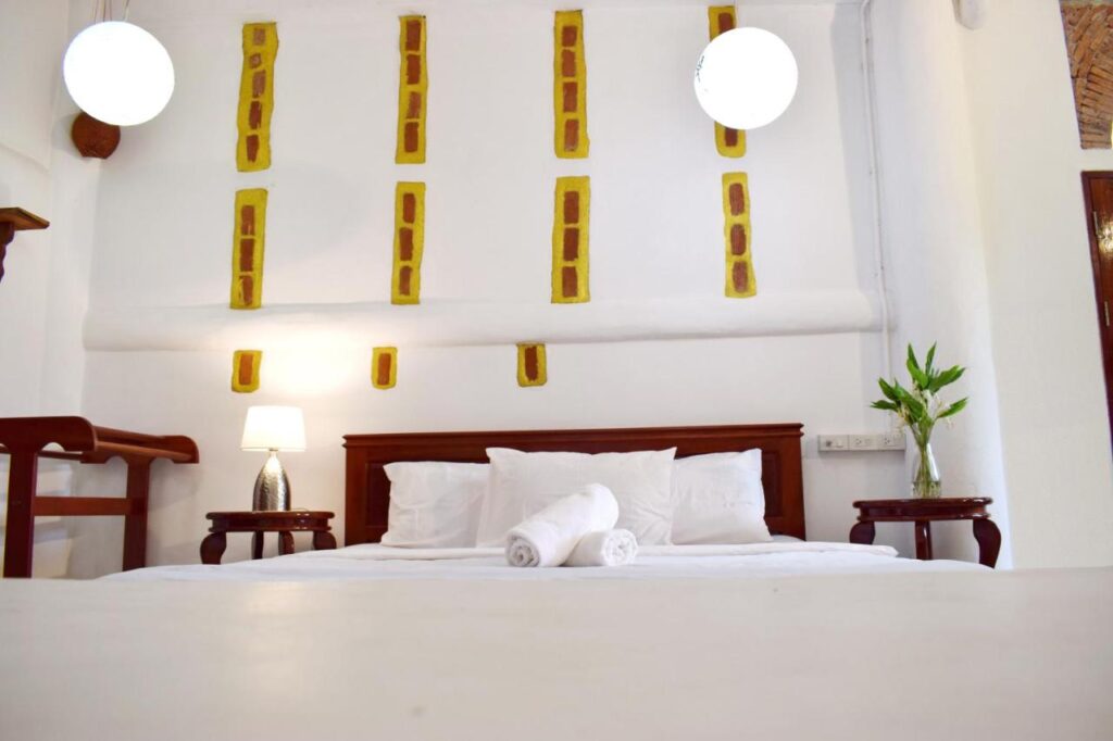 ห้องที่มีเตียงและโต๊ะข้างเตียงในที่พักท่องเที่ยวน่าน สังขละบุรีที่พัก