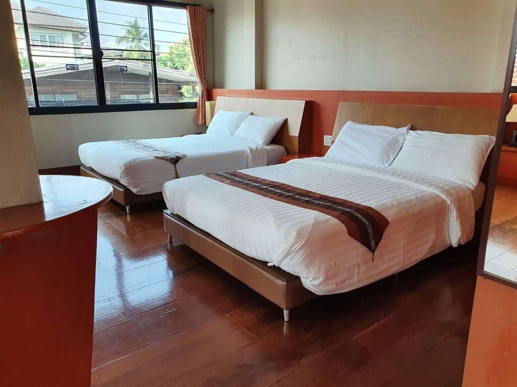 เตียงสองเตียงในห้องที่มีพื้นไม้ รีสอร์ทพะเยา