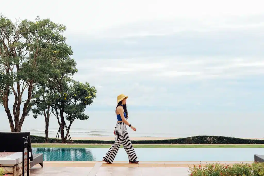 ผู้หญิงกำลังเดินอยู่ริมสระน้ำพร้อมวิวทะเลที่บ้านติดทะเลหัวหิน บ้านพักหัวหินติดทะเล