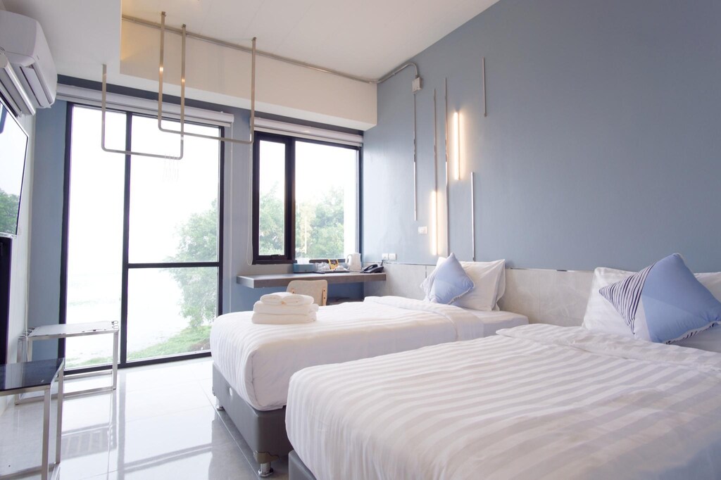 เตียงสองเตียงในห้องที่มีผนังสีฟ้า ที่พักพะเยา