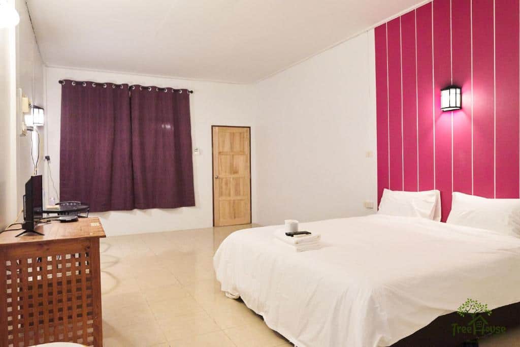 ห้องนอนที่มีผนังลายสีชมพูและเตียงสีขาวเป็นสถานที่พักผ่อนที่สะดวกสบาย  ที่พักทะเลหมอกเบตง