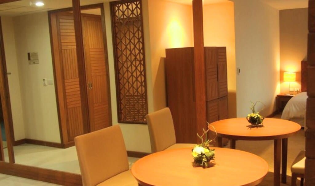 ห้องที่มีโต๊ะและเก้าอี้และกระจก ที่พักอุบลราชธานี