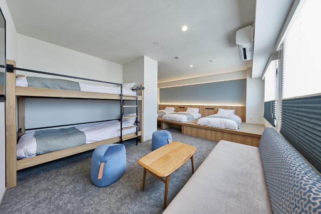 ห้องพักพร้อมเตียงสองชั้นและโซฟา เหมาะสำหรับนักเดินทางที่ต้องการพักผ่อนหลังจากท่องเที่ยวมาทั้งวัน ที่เที่ยวญี่ปุ่น