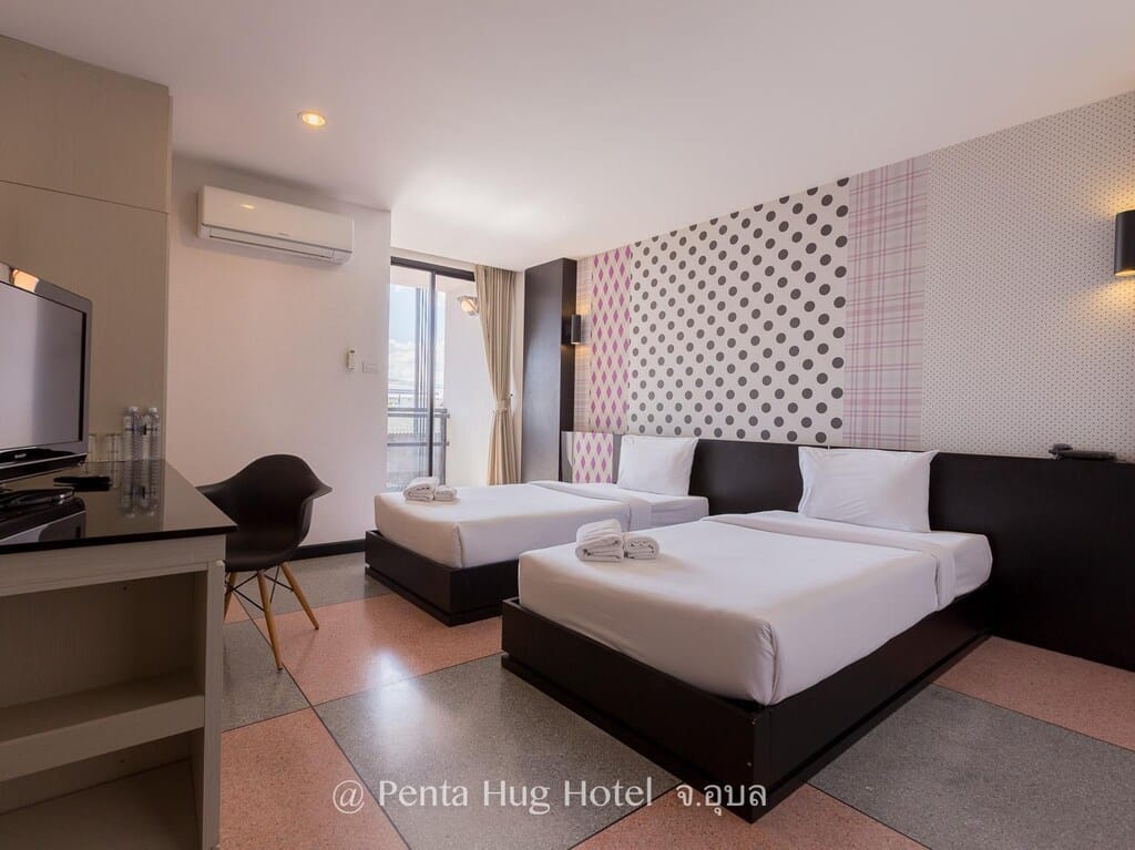 ห้องพักในโรงแรมที่มีสองเตียงและโต๊ะ ที่พักอุบลราชธานี