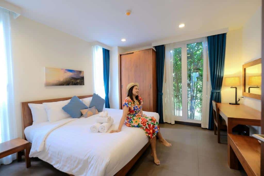 ผู้หญิงคนหนึ่งนั่งอยู่บนเตียงในห้องพักของโรงแรมแห่งหนึ่งในหัวหิน ประจวบคีรีขันธ์ ประเทศไทย พูลวิลล่าหัวหิน