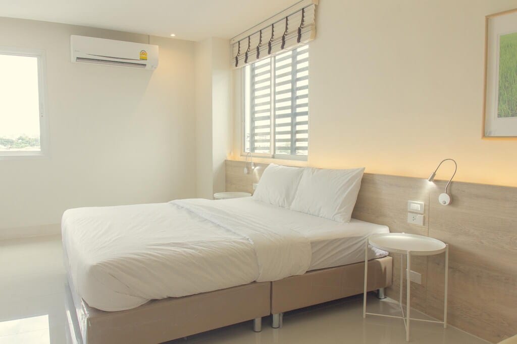 ห้องที่มีเตียงสีขาวและผนังสีขาว ที่เที่ยวลพบุรี
