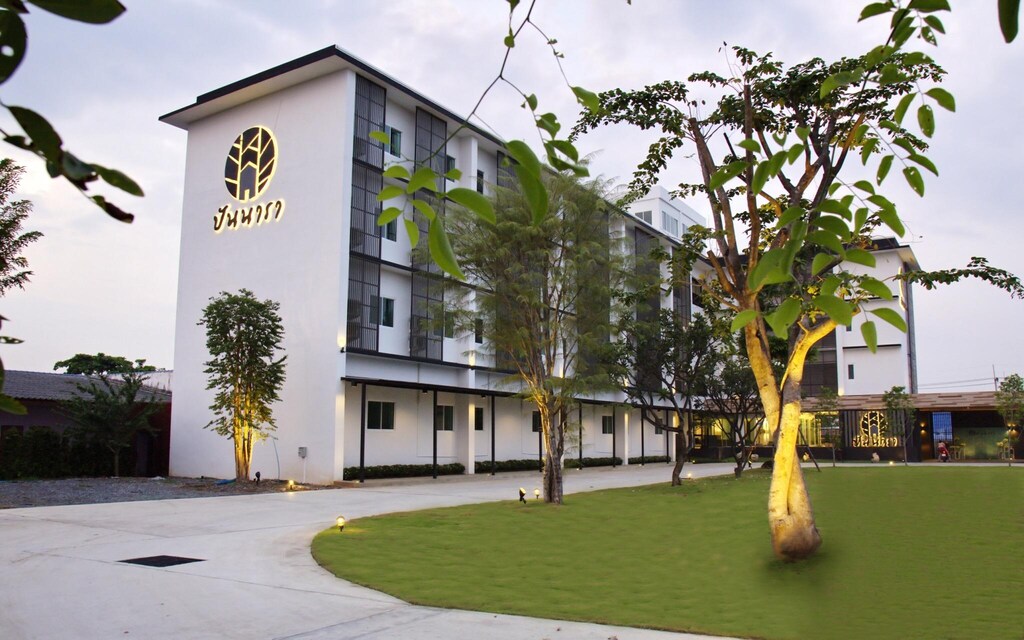 โรงแรมที่มีสนามหญ้าและต้นไม้อยู่ด้านหน้า ที่เที่ยวลพบุรี