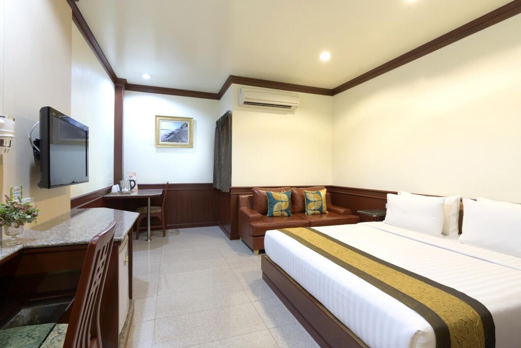 ห้องพักในโรงแรมที่มีเตียงและโทรทัศน์ ที่พักอุบล