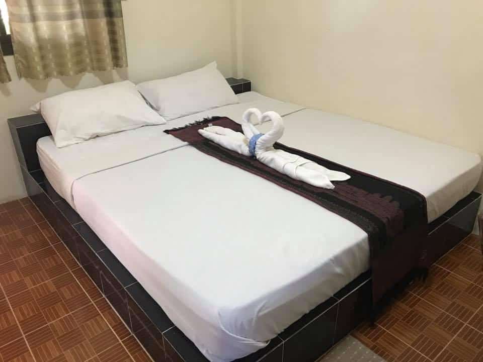 เตียงในห้องที่มีผ้าเช็ดตัวอยู่ โรงแรมอุบล