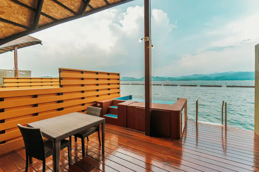 ดาดฟ้าพร้อมโต๊ะและเก้าอี้ที่มองเห็นผืนน้ำในน่านที่เที่ยว สังขละบุรีที่พัก