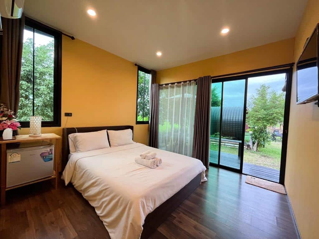 ห้องนอนผนังสีเหลือง ที่พักปัว พื้นไม้ ตั้งอยู่ในเที่ยวน่าน