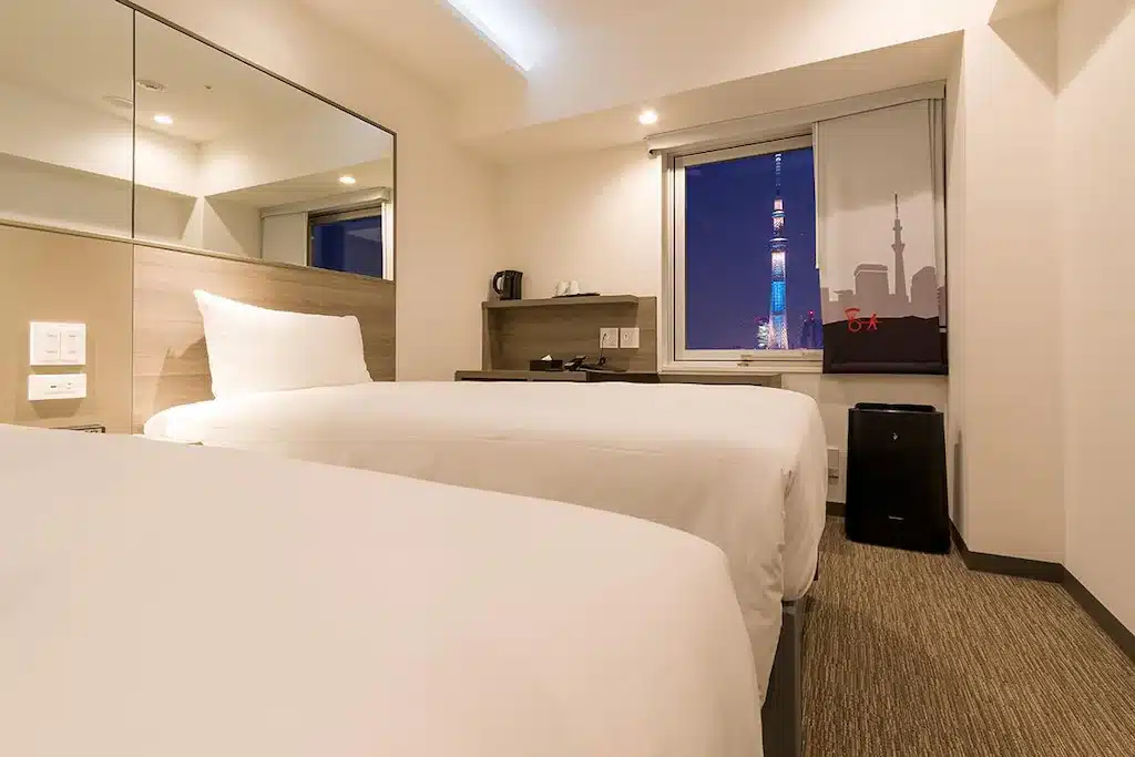 เตียงสองเตียงในห้องพักโรงแรมพร้อมทิวทัศน์ของเมืองราชบุรีประเทศไทย ที่เที่ยวญี่ปุ่น