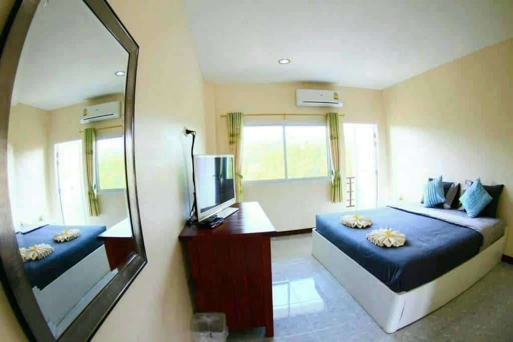 ห้องที่มีเตียงและกระจกอยู่ในสถานที่ท่องเที่ยวน่าน. ที่พักสังขละบุรี ที่พักสังขละบุรี