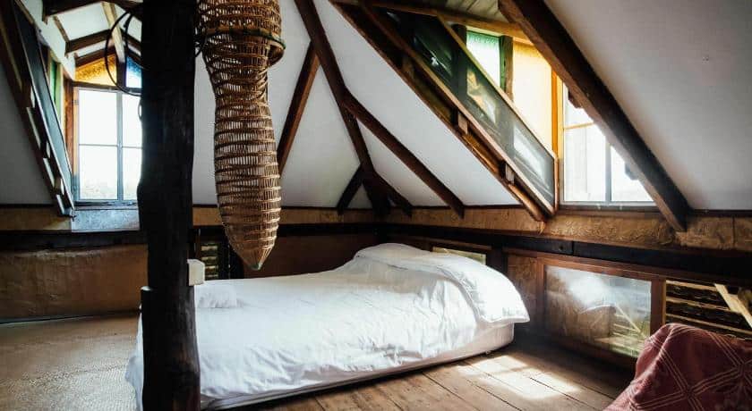 เตียงในห้องใต้หลังคาที่มีคานไม้ ที่พักพะเยา
