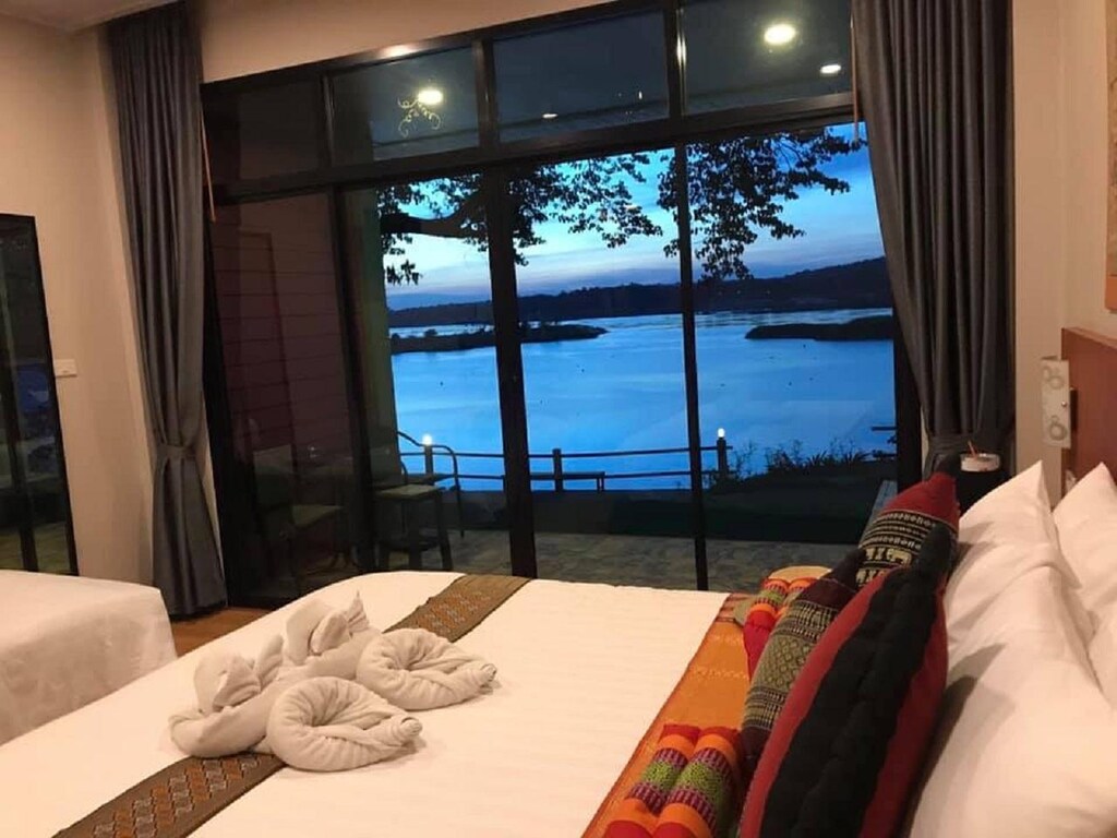 เตียงในห้องที่มองเห็นวิวทะเลสาบ โรงแรมอุบล