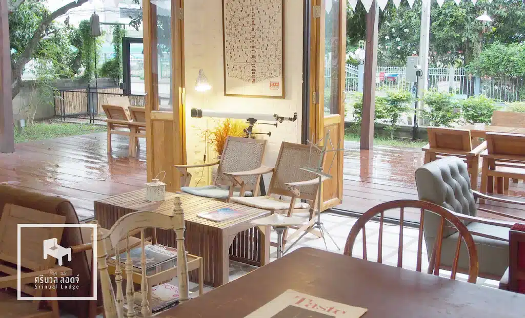 ร้านกาแฟที่มี ที่พักปัว โต๊ะและเก้าอี้ไม้และประตูกระจก